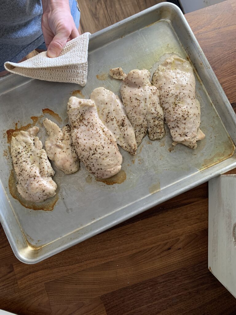 Cooked chicken breasts on cookie sheet