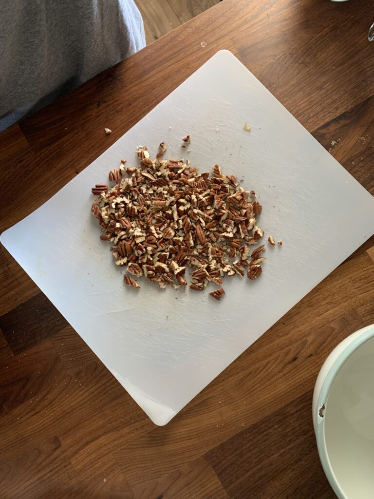 Roasted and chopped pecans on a cutting board