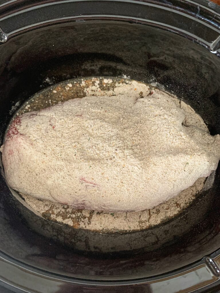 roast covered in spices in slow cooker