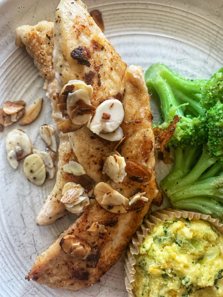 chicken fingers with almonds and muffin and broccoli