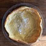 photo of mom's puff pancake in pie pan topped with powdered sugar