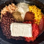 all ingredients for white chicken chili separated in crock pot